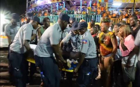 People look at an injured person being carried away after a carnival float hit power lines, on the second day of the annual Carnival celebrations in Haiti's capital Port-au-Prince in this February 17, 2015 still image taken from Reuters TV. PHOTO BY REUTERS/Reuters TV