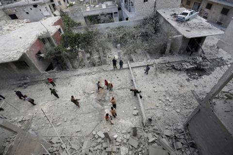 People inspect the damage at a site hit by airstrikes in the rebel-controlled area of Maaret al-Numan town in Idlib province. PHOTO BY REUTERS/Khalil Ashawi