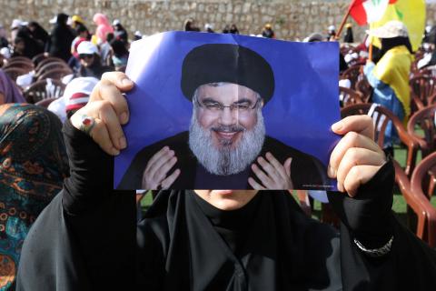 A supporter of Lebanon's Hezbollah leader Sayyed Hassan Nasrallah carries his picture during a rally marking al-Quds Day, (Jerusalem Day) in Maroun Al-Ras village, near the border with Israel, southern Lebanon, June 8, 2018. PHOTO BY REUTERS/Aziz Taher