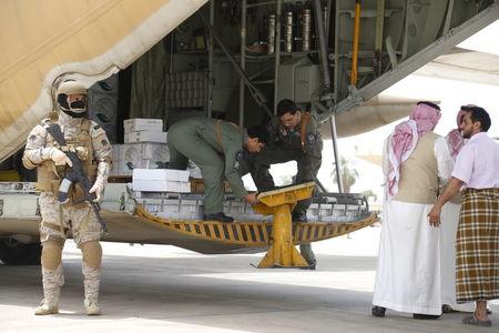A Saudi soldier stands guard as servicemen on a Saudi military cargo plane prepare to unload aid at the international airport of Yemen's southern port city of Aden, July 24, 2015. PHOTO BY REUTERS/Faisal Al Nasser