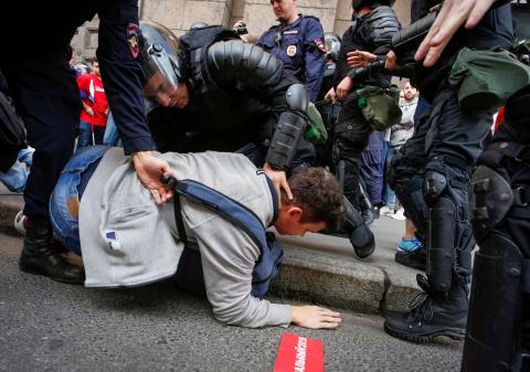 Police officers detain a protester during a rally against planned increases to the nationwide pension age in St. Petersburg, Russia. PHOTO BY REUTERS/Anton Vaganov