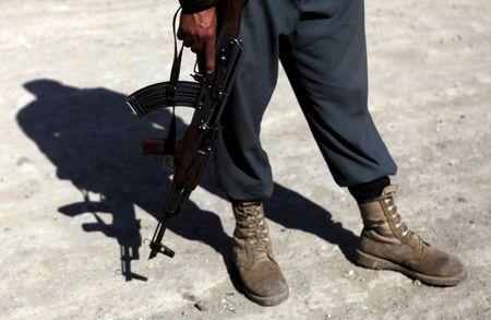 An Afghan policeman with a weapon stands at the site of a suicide attack in Kabul, in this file picture taken July 2, 2013. PHOTO BY REUTERS/Mohammad Ismail