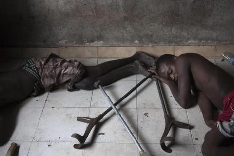 Youths suffering from polio sleep beside crutches at the Stand Proud compound in Kinshasa. PHOTO BY REUTERS/Finbarr O'Reilly
