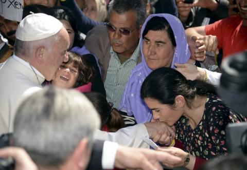 A woman shakes the hand of Pope Francis and gives him a piece of paper as he greets migrants and refugees at the Moria refugee camp near the port of Mytilene, on the Greek island of Lesbos, April 16, 2016. PHOTO BY REUTERS/Filippo Monteforte