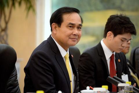 Thailand's Prime Minister Prayuth Chan-ocha (C) listens as he meets with China's President Xi Jinping (not pictured) at the Great Hall of the People in Beijing, December 23, 2014. PHOTO BY REUTERS/Wang Zhao