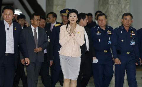 Thailand's Prime Minister Yingluck Shinawatra gestures while speaking to reporters following following the declaration of a state of emergency in Bangkok