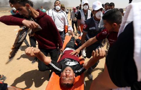 A wounded Palestinian is evacuated during a protest where Palestinians demand the right to return to their homeland, at the Israel-Gaza border in the southern Gaza Strip, May 11, 2018. PHOTO BY REUTERS/Ibraheem Abu Mustafa