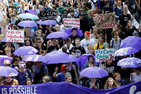 People hold banners and umbrellas as they walk during the protest demonstration at the G20 summit in Hamburg, Germany, July 7, 2017. PHOTO BY REUTERS/Fabrizio Bensch