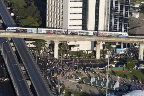 An elevated train passes over an intersection that is being blocked by anti-government protesters in central Bangkok