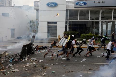 Demonstrators run as they clash with police during a rally against Venezuela's President Nicolas Maduro in Caracas, Venezuela. PHOTO BY REUTERS/Carlos Garcia Rawlins