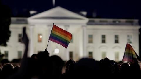 A rainbow flag is held up during a vigil after the worst mass shooting in U.S. history at a gay nightclub in Orlando, Florida, in front of the White House in Washington, U.S., June 12, 2016. PHOTO BY REUTERS/Joshua Roberts
