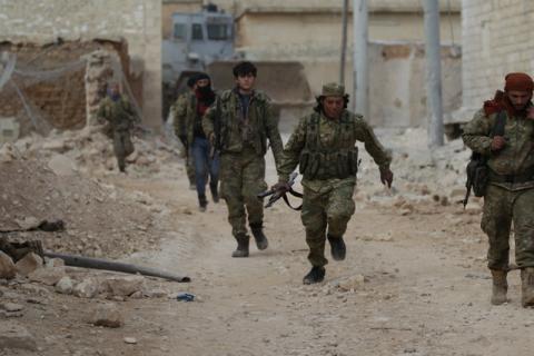 A rebel fighter runs with a weapon on the outskirts of the northern Syrian town of al-Bab, Syria, January 26, 2017. PHOTO BY REUTERS/Khalil Ashawi
