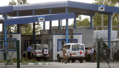 Cars of the Red Cross and trucks of a Russian convoy carrying humanitarian aid for Ukraine are seen at a Russia-Ukraine border crossing point "Donetsk" during a control check in Rostov Region