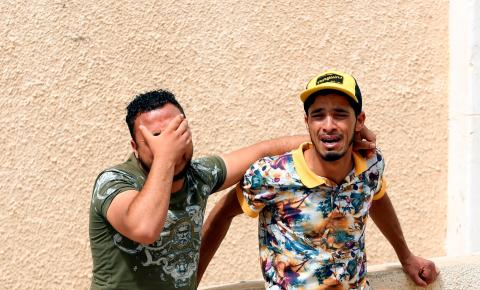 Relatives of Tunisian migrants, who drowned when their boat sank, react as they leave a hospital morgue after identifying the bodies of their family members, in Sfax, Tunisia, June 4, 2018. PHOTO BY REUTERS/Zoubeir Souissi