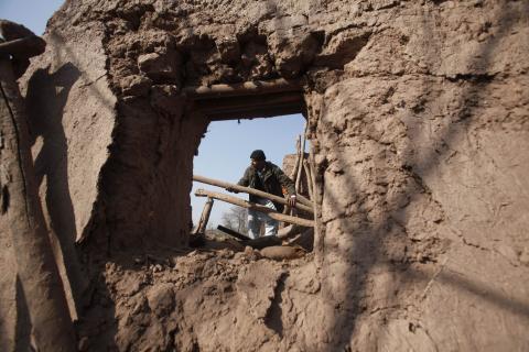 A resident collects items from the rubble of a house after it was damaged by grenades from gunmen on the outskirts of the northwestern city of Peshawar