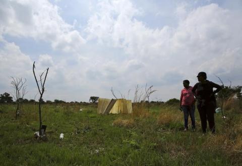 Residents stand in front of markings with sticks at an open land in Nellmapius township, 20 km (12 miles) east of Pretoria, November 13, 2014. PHOTO BY REUTERS/Siphiwe Sibeko