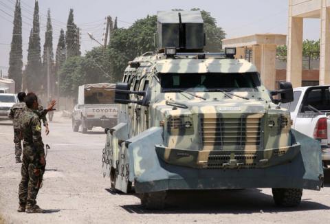 A Syrian Democratic Forces (SDF) fighter gestures towards an armoured vehicle in Hawi Hawa village, west of Raqqa, Syria, June 11, 2017. PHOTO BY REUTERS/Rodi Said