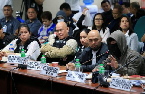 A witness to a recent teen killing linked to illegal drugs, wearing a sweatshirt and mask to hide his identity gestures while parents of the killed teenager, wearing bulletproof vests listen during the Senate investigation on illegal drugs at the Senate headquarters in Pasay city, metro Manila, Philippines October 2, 2017. PHOTO BY REUTERS/Romeo Ranoco