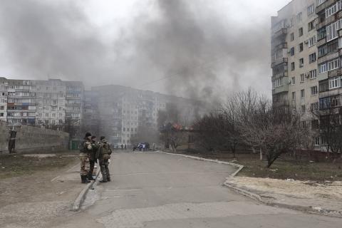 Ukrainian servicemen stand guard on a street near the burning building after a shelling by pro-Russian rebels of a residential sector in Mariupol, eastern Ukraine, January 24, 2015. PHOTO BY REUTERS/Nikolai Ryabchenko