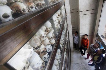 People look at skulls and bones of more than 8,000 victims of the Khmer Rouge regime during a Buddhist ceremony at Choeung Ek, a "Killing Fields" site located on the outskirts of Phnom Penh, April 17, 2015. PHOTO BY REUTERS/Samrang Pring