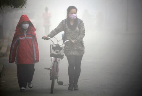 People walk along a street during a smoggy day in Jilin, Jilin province, October 22, 2013. PHOTO BY REUTERS/Stringer