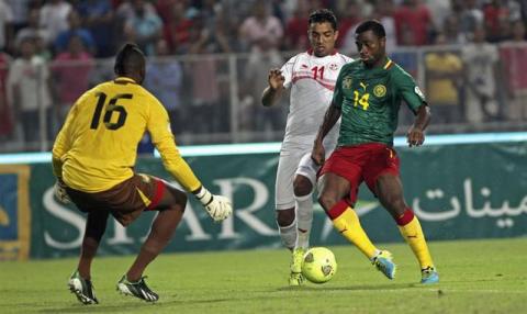 Tunisia's Sami Allagui (C) fights for the ball with Cameroon's Aurelien Chedjou (R) during their 2014 World Cup qualifying soccer match at Rades Stadium in Tunis