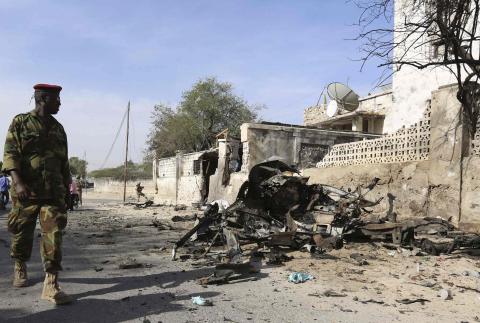 A Somali government soldier secures the scene of a suicide attack next to the gate of the Presidential Palace in Mogadishu