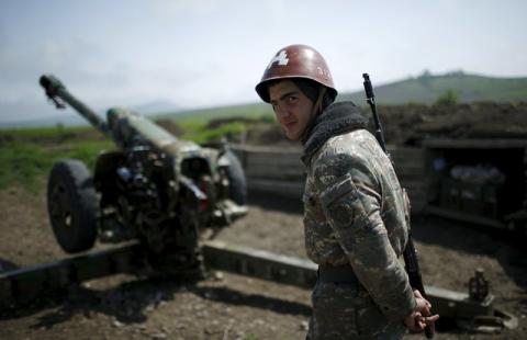 An ethnic Armenian soldier stands next to a cannon at the artillery positions near Nagorno-Karabakh's town of Martuni, April 8, 2016. PHOTO BY REUTERS/Staff