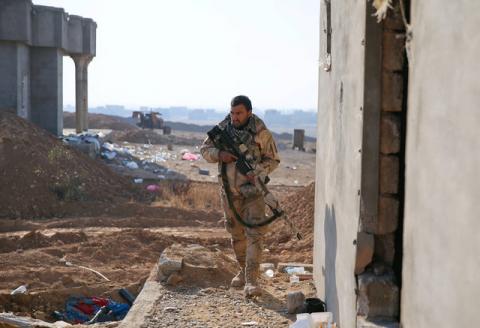 A member of the Iraqi Army walks during clashes with Islamic State militants at the south of Mosul, Iraq, December 12, 2016. PHOTO BY REUTERS/Ammar Awad