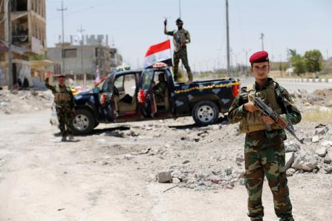 Iraqi government forces react to the camera in Falluja after government forces recaptured the city from Islamic State militants, Iraq, July 1, 2016. PHOTO BY REUTERS/Thaier Al-Sudani