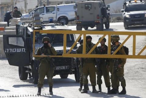Israeli soldiers stand guard near the scene where a Palestinian, who the Israeli military said attempted to stab Israeli security forces with a screwdriver, after he was shot dead at a checkpoint near the West Bank city of Hebron, December 24, 2015. PHOTO BY REUTERS/Mussa Qawasma