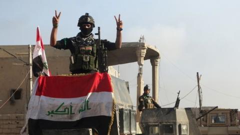 A member of the Iraqi security forces gestures at a government complex in the city of Ramadi, December 28, 2015. PHOTO BY REUTERS/Stringer