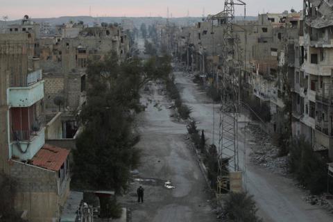 A man walks along a deserted street filled with debris in Deir al-Zor, eastern Syria, February 14, 2014. PHOTO BY REUTERS/Khalil Ashawi