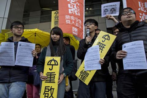 Hong Kong student leaders (L-R) Oscar Lai, Agnes Chow, Joshua Wong and Derek Lam speak as they arrive at the police headquarters in Hong Kong, January 16, 2015. PHOTO BY REUTERS/Tyrone Siu