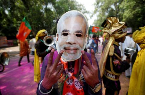 A supporter of Bharatiya Janata Party (BJP) celebrates after learning of the initial poll results outside the party headquarters in New Delhi, March 11, 2017. PHOTO BY REUTERS/Adnan Abidi