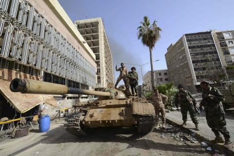 Members of the Libyan pro-government forces, backed by locals, gather on a tank outside the Central Bank, near Benghazi port, January 21, 2015. PHOTO BY REUTERS/Esam Omran Al-Fetori 