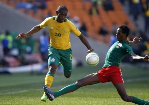 South Africa's Thulani Hlatshwayo (L) is challenged by Burkina Faso's Daila Pierre during the inaugural Nelson Mandela Sport and Culture Day at the soccer city stadium in Soweto, August 17, 2013. PHOTO BY REUTERS/Siphiwe Sibeko