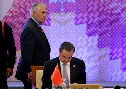 U.S. State Secretary Rex Tillerson, left, passes by the table of Chinese Foreign Minister Wang Yi at the start of the 7th East Asia Summit Foreign Ministers' Meeting and its dialogue partners as part of the 50th ASEAN Ministerial Meetings in Manila, Philippines, August 7, 2017. PHOTO BY REUTERS/Aaron Favila