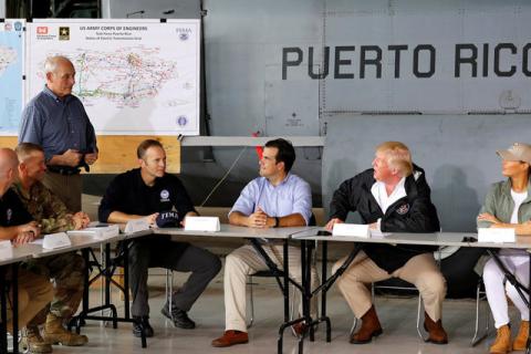 U.S. President Donald Trump addresses White House Chief of Staff John Kelly (L) before a briefing on hurricane relief efforts in a hangar at Muniz Air National Guard Base in Carolina, Puerto Rico, U.S. October 3, 2017. PHOTO BY REUTERS/Jonathan Ernst