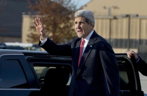 U.S. Secretary of State John Kerry waves before getting into his motorcade vehicle as he arrives at Andrews Air Force Base, Maryland
