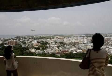 Visitors look out over U.S. Marine Corps Air Station Futenma in Ginowan on Okinawa May 3, 2010. PHOTO BY REUTERS/Issei Kato