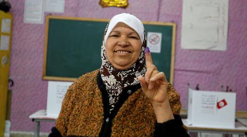 A woman raises her ink-stained finger after casting her vote at a polling station for the municipal election in Tunis, Tunisia, May 6, 2018. PHOTO BY REUTERS/Zoubeir Souissi