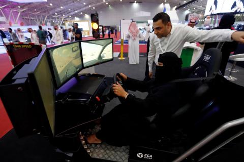 A Saudi woman tries a car simulator during women car show in Riyadh, Saudi Arabia, May 13, 2018. PHOTO BY REUTERS/Faisal Al Nasser