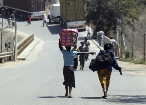 Women carry their belongings as they cross the border between Mozambique and Zimbabwe, September 18, 2010. PHOTO BY REUTERS/Goran Tomasevic