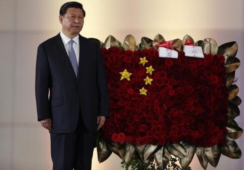 China's President Xi Jinping stands next to a flower arrangement depicting China's national flag during a ceremony at the National Pantheon in Caracas, July 20, 2014. PHOTO BY REUTERS/Carlos Garcia Rawlins