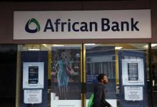 A man walks past a branch of African Bank in Cape Town, August 8, 2014. PHOTO BY REUTERS/Mike Hutchings