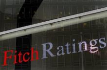 A flag is reflected on the window of the Fitch Ratings headquarters in New York, February 6, 2013. PHOTO BY REUTERS/Brendan McDermid