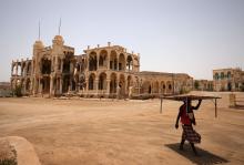A man carries a table as he walks past the ruins of a building in the port city of Massawa, Eritrea, July 22, 2018. PHOTO BY REUTERS/Tiksa Negeri