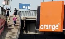 People walk past a sign of French telecom operator Orange hanging from a bridge in Cairo, Egypt, March 13, 2016. PHOTO BY REUTERS/Amr Abdallah Dalsh