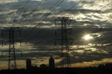 Electricity pylons in Johannesburg's Alexandra township stand against the skyline of the city's Sandton business district. PHOTO BY REUTERS/Mike Hutchings